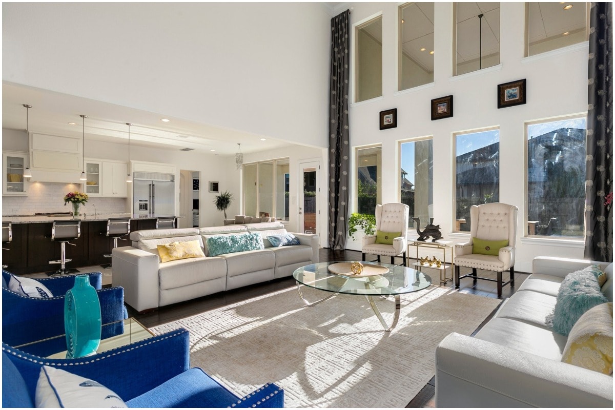 large windows clean white living room blue chair