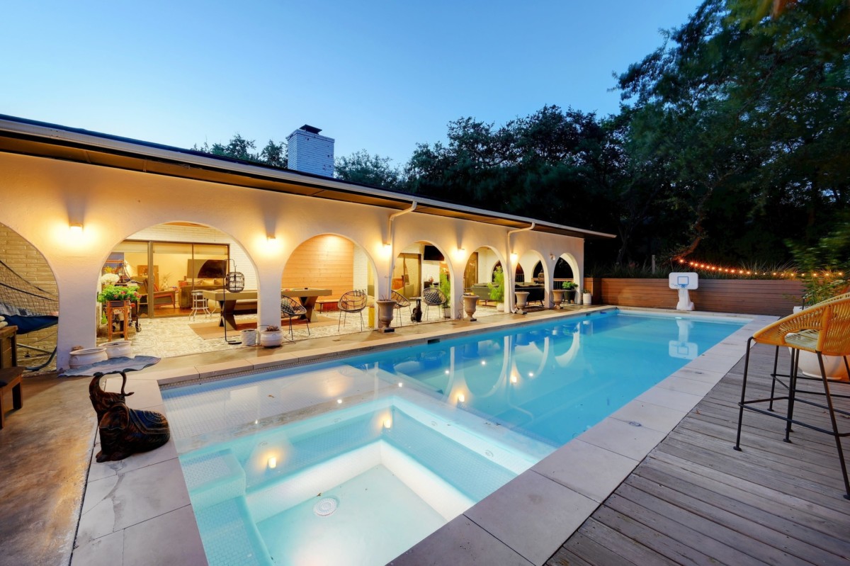 backyard of a mediterranean home exterior with a pool and arched indoor outdoor space