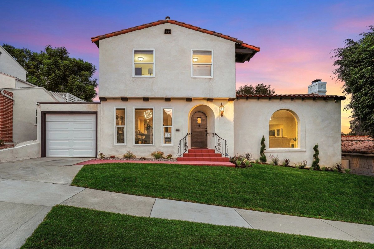spanish colonial mediterranean home with two stories and an attached garage