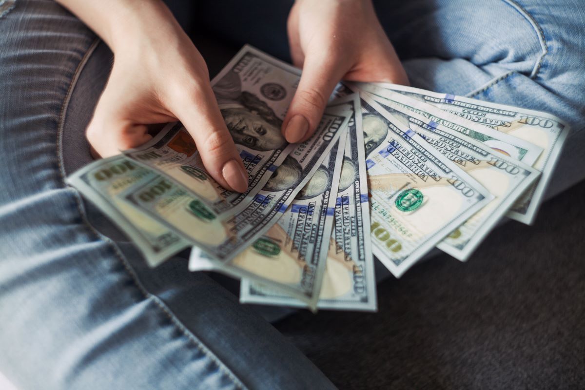 person holding one hundred dollar bills