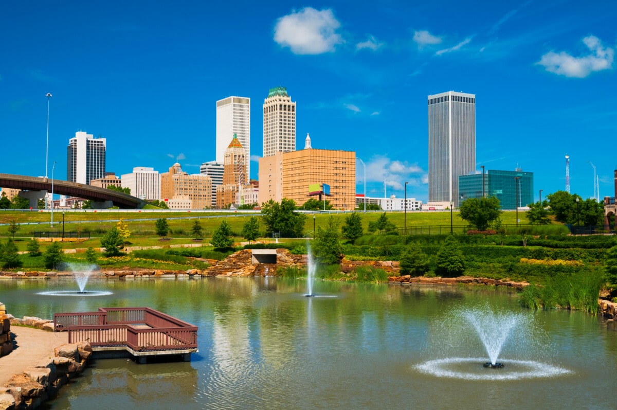 "Tulsa skyline with a park, pond, and fountains in the foreground."