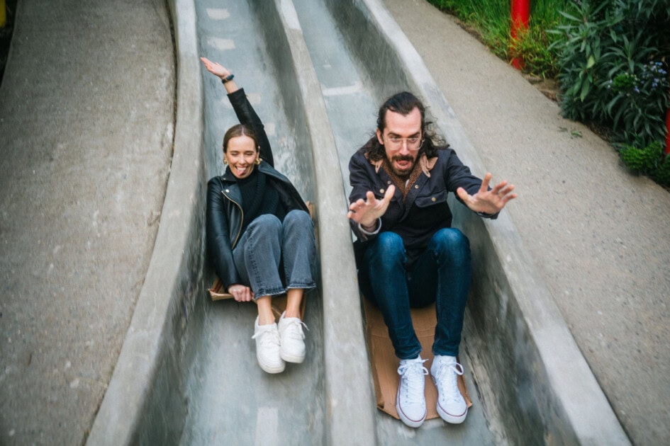 Two people sliding down concrete slides in San Francisco