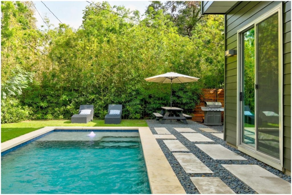 backyard with large trees and blue pool