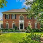 Two story, brick colonial style homes with dark blue shutters
