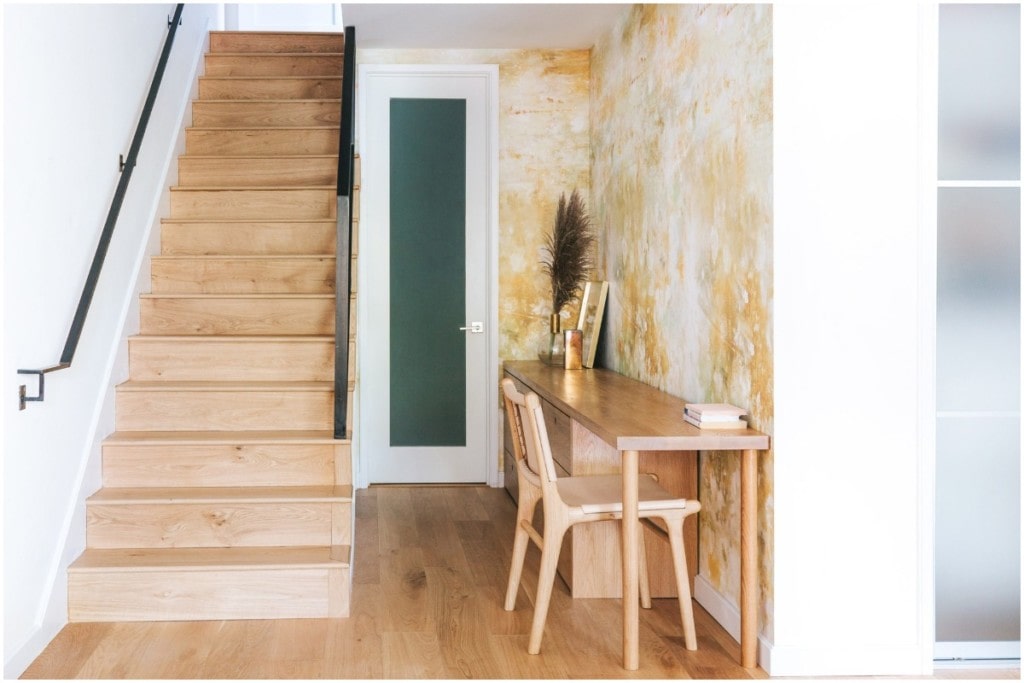 wood stair case hallway with wood desk and chair