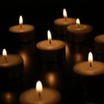 Lit tea light candles in the dark