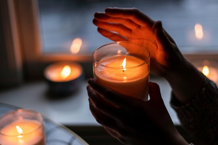 Person holding lit candle